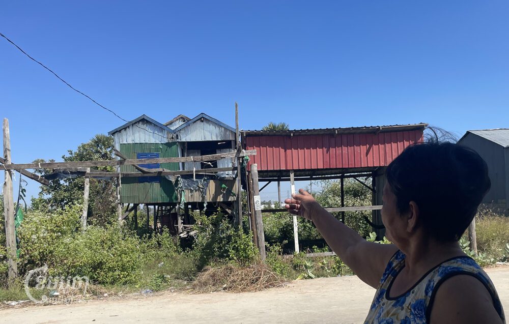 Kong Srey points to an abandoned house owned by two people who had been evicted from the Boeng Tamok community along with her in 2022 on December 29, 2023. (CamboJA / Phon Sothyroth)