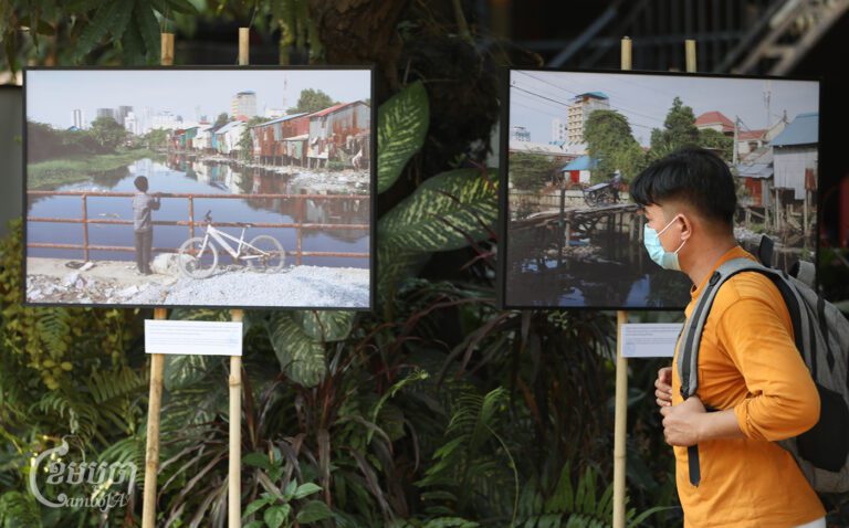 A young man views the photos displayed at Champei Garden Restaurant in Niroth commune on February 23, 2024. (CamboJA / Pring Samrang)
