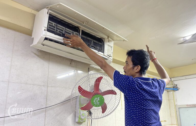 A technician cleans an air conditioner in a house in Phnom Penh on May 24, 2024. (CamboJA/Pring Samrang)