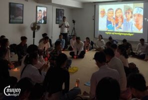 A group of youths gather inside a room at CENTRAL office for a two-minute prayer for the Mother Nature Cambodia environmental activists who were imprisoned last year, on July 1, 2025. (CamboJA/Sovann Sreypich)